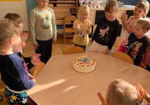 6 urodziny Zosi. Dzieci zgromadzone wokół stołu na którym leży tort.